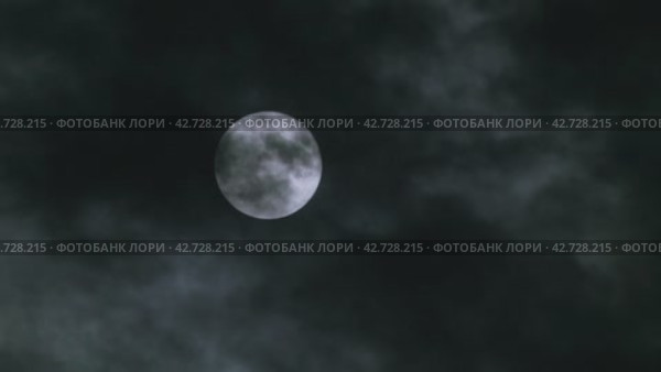 Облака движутся мимо яркой полной луны в ночном небе. Таинственная атмосфера фильма ужасов. Крупный план. Стоковое видео, видеограф Воловодов Владимир / Фотобанк Лори