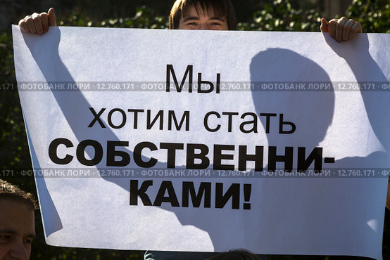Обманутый дольщик строительной компанией держат плакат с надписью "Мы хотим стать собственниками!" (2015 год). Редакционное фото, фотограф Николай Винокуров / Фотобанк Лори
