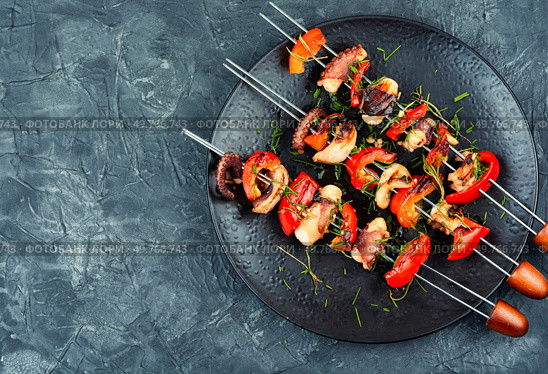 Octopus and bell pepper kebabs on iron skewers. Traditional Japanese BBQ grill. Flat lay. Space for text.. Grilled octopus on skewers. Стоковое фото, агентство Ingram Publishing / Фотобанк Лори