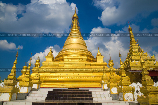 Одна из золотых ступ буддистского храма Kuthodaw Pagoda  на фоне облачного неба. Мандалай, Мьянма (Бирма) (2016 год). Стоковое фото, фотограф Виктор Карасев / Фотобанк Лори