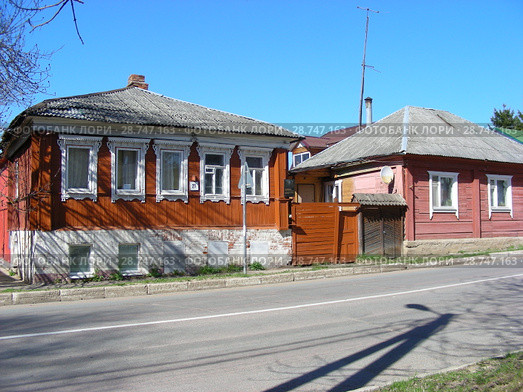 Одноэтажный деревянный жилой дом с высоким цоколем (Советская улица, 21). Одноэтажный деревянный жилой дом в частном секторе (Советская улица, 23/8). Город Волоколамск. Московская область (2015 год). Редакционное фото, фотограф lana1501 / Фотобанк Лори