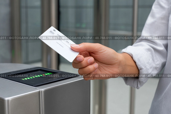 Office worker using electronic key card to open turnstile gate. Стоковое AI-изображение, AI-художник Юрий Поздников / Фотобанк Лори