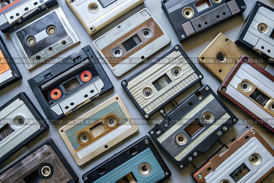 Old audio cassettes with retro music. View from above. Music media from previous years. Стоковое AI-изображение, AI-художник Photojuli / Фотобанк Лори