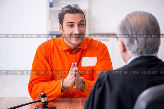 Old male judge meeting with young captive in courthouse. Стоковое фото, фотограф Elnur / Фотобанк Лори