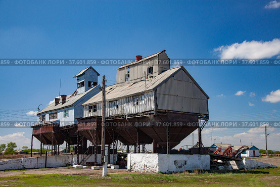 Old outdated Soviet grain storage. Cone hopper for truck loading downside. Blue sky, cloud. Стоковое фото, фотограф Alexey Rezvykh / Фотобанк Лори