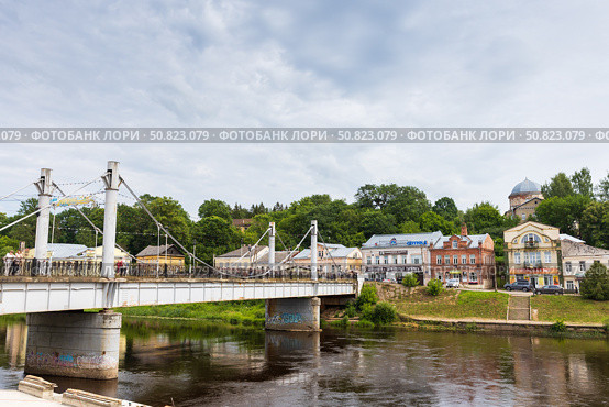 Old town view featuring Pedestrian bridge over Tvertsa river under cloudy sky. Редакционное фото, фотограф EugeneSergeev / Фотобанк Лори