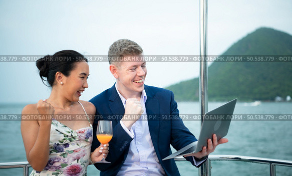 On a yacht, a businessman begins his family’s vacation. a huge project agreement was successfully closed, which was wonderful news. Стоковое фото, агентство Ingram Publishing / Фотобанк Лори