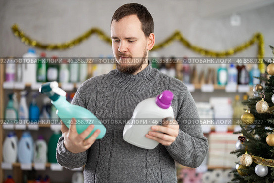 On New Year Eve, man choose and buy liquid washing powder and tile cleaner spray. Стоковое фото, фотограф Яков Филимонов / Фотобанк Лори