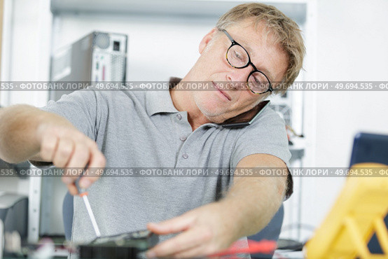 on the table the tablet is disassembled and tools. Стоковое фото, агентство Ingram Publishing / Фотобанк Лори