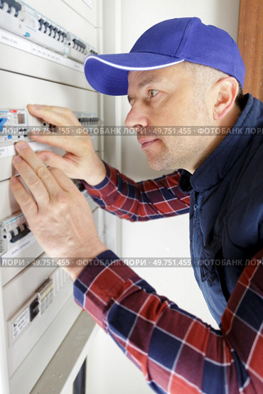 one electrician builder at work installing fuseboard. Стоковое фото, агентство Ingram Publishing / Фотобанк Лори