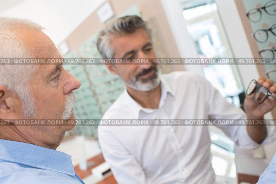 optician showing the patient a pair of eyeglasses. Стоковое фото, агентство Ingram Publishing / Фотобанк Лори