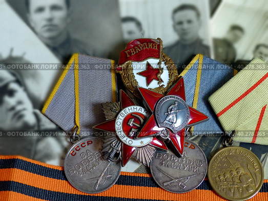 Ордена «Красной Звезды» и «Отечественной войны», знак «Гвардия», медали, старые фотографии иа георгиевская лента. Награды фронтовика. Семейная реликвия. Память. 9 мая День Победы. Стоковое фото, фотограф Сергей Елизарьев / Фотобанк Лори