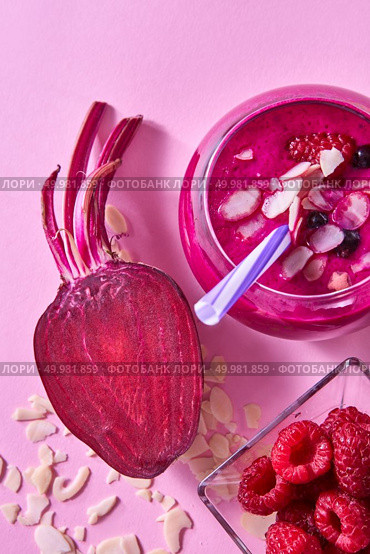 Organic freshly picked vegetables and fruits for preparing healthy vegetarian smoothie in a glass jar on pink paper. Flat lay.. Homemade red smoothies with beet, raspberries and black currants, almond flakes on a pink paper background. Стоковое фото, агентство Ingram Publishing / Фотобанк Лори
