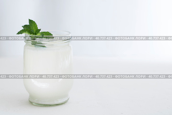 Organic probiotic milk kefir drink or yogurt in glass containers,on the white grey background. Gut health. Probiotic cold fermented dairy drink. Trendy food and drink. Copy space. Стоковое фото, фотограф Tatiana Syrtseva / Фотобанк Лори