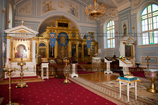 Orthodox church. Candles, cross, icon, prayer book, candles and Bible on table, Iconostasis, baptismal font. Preparing for baptism of newborn child in Holy water. Sacrament of baptism. Стоковое фото, фотограф Aleksandr Golubev / Фотобанк Лори