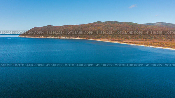 Осенняя аэрофотосъёмка морского побережья. Вид сверху на морской залив, побережье и горы. Солнечная погода. Амахтонский залив, Тауйская губа, Охотское море. Природа Магаданской области и Сибири. Дальний Восток России. Стоковое фото, фотограф Андрей Степанов / Фотобанк Лори