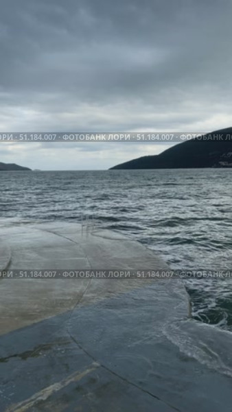 Overcast seascape with mountains and cloudy sky viewed from concrete pier background. Стоковое видео, видеограф Анастасия Золотницкая / Фотобанк Лори