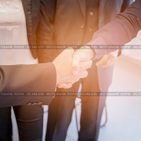 overhead view two businessman shaking hands together. Стоковое фото, агентство Ingram Publishing / Фотобанк Лори