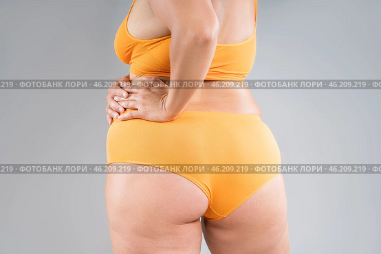 Overweight thigh, woman with fat hips, legs and buttocks, obesity female body with cellulite on gray background. Стоковое фото, фотограф Станислав Тарко / Фотобанк Лори