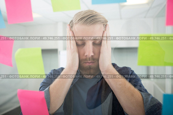 overwhelmed man surrounded by colourful post-its. Стоковое фото, агентство Ingram Publishing / Фотобанк Лори