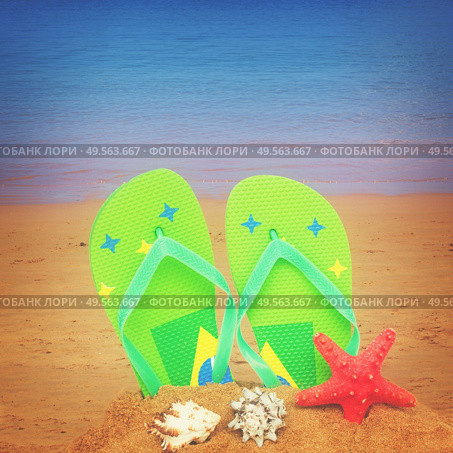 pair of green sandals and starfish in sand isolated on white background, retro toned. green sandals and starfish in sand. Стоковое фото, агентство Ingram Publishing / Фотобанк Лори