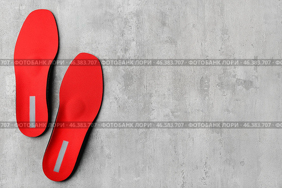 Pair of red orthopedic insoles on grunge background. Стоковое фото, фотограф Pixel_shot / Фотобанк Лори