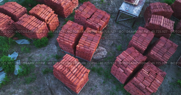 Pallets of bricks for construction. Outdoor storage. Warehousing of large quantities of bricks. Aerial view. Стоковое видео, видеограф Георгий Мякишев / Фотобанк Лори