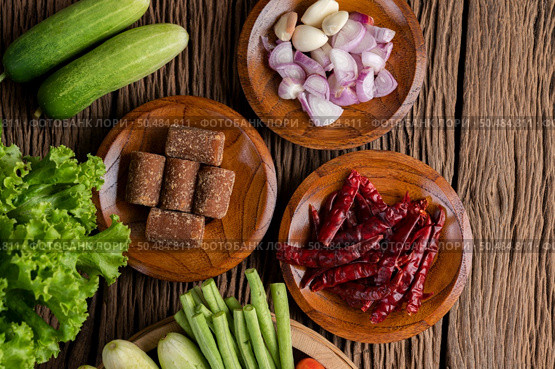 Palm sugar, red onions, dried peppers, tomatoes, cucumbers, yard long beans and lettuce in a bowl. Стоковое фото, агентство Ingram Publishing / Фотобанк Лори