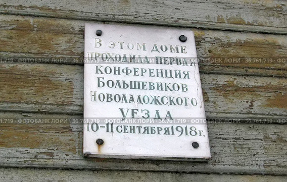 Памятная табличка на историческом здании, в котором проходила первая конференция Большевиков Новоладожского уезда 10-11 сентября 1918 года. Город Новая Ладога Волховского района Ленинградской области (2014 год). Стоковое фото, фотограф Румянцева Наталия / Фотобанк Лори