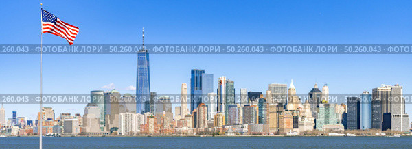 Panorama of Lower Manhattan of New York City with USA Flag from liberty island. This also known as Downtown Manhattan or Downtown New York the largest business district in state of New York and USA. Стоковое фото, агентство Ingram Publishing / Фотобанк Лори