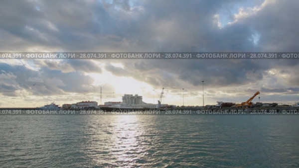 Panoramic view of Sochi sea port, Olympic rings in the sunset light, calm sea (2017 год). Стоковое видео, видеограф Ирина Мойсеева / Фотобанк Лори