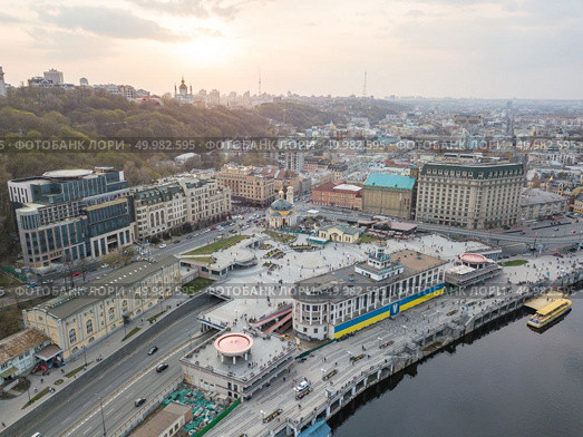 Panoramic view of the river station with walking ferries. Postal square, St. Andrew’s Church and a television tower in the distance at sunset on Podol in Kiev, Ukraine. Photo from the drone. Panoramic view of the river station and Postal square at the sunset in Podil in Kiev, Ukraine. Стоковое фото, агентство Ingram Publishing / Фотобанк Лори