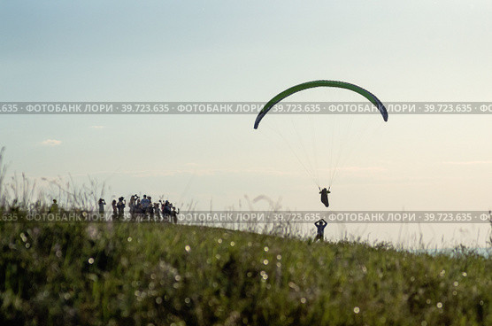 Парапланерист взлетает с вершины горы. A paraglider takes off from the top of a mountain. (2018 год). Редакционное фото, фотограф Евгений Романов / Фотобанк Лори