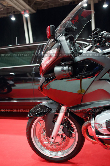 Part of black bike for cortege, car are on red carpet in exhibition. Стоковое фото, фотограф Losevsky Pavel / Фотобанк Лори