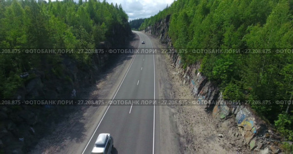 Пассажирские автомобили проезжают по дороге, проложенной среди скал. Стоковое видео, видеограф Кекяляйнен Андрей / Фотобанк Лори