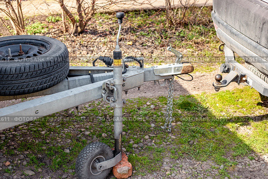 Passenger car next to the trailer coupling, metal drawbar with spare wheel, rolling wheel. Стоковое фото, фотограф Коханова Наталья / Фотобанк Лори