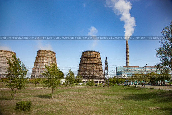 Pavlodar thermal electric station. Cooling towers and smoke stack with white smoke. Green grass field. Стоковое фото, фотограф Alexey Rezvykh / Фотобанк Лори
