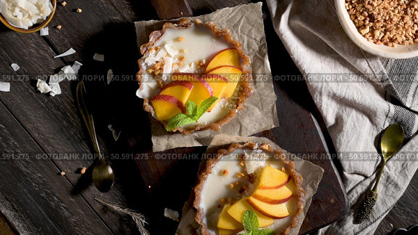 Peach vegan tarts with grated coconut  and crunchy peanuts. Fruit cake. Date, walnut, almond and hazelnut base. Стоковое фото, агентство Ingram Publishing / Фотобанк Лори