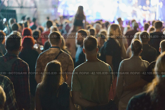 People are excited during street concert. Blue neon lighting.. Young woman sits on the shoulders of her boyfriend. People make photos, video records. Night life. Street photography. Стоковое фото, фотограф YuryKara / Фотобанк Лори