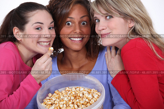 Peppy women eating popcorn. Стоковое фото, агентство Ingram Publishing / Фотобанк Лори