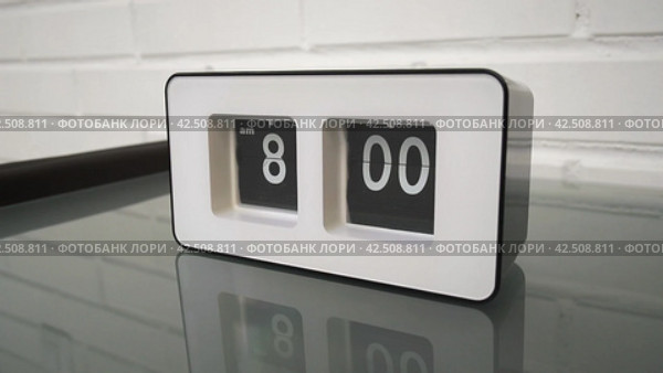 Перекидной циферблат часов будильника. Монтаж двух планов. Flip clock mechanism. 8:00 AM. Flip clock watch face. White brick wall in the background. Slow motion 240 fps. Стоковое видео, видеограф EStarodubov / Фотобанк Лори