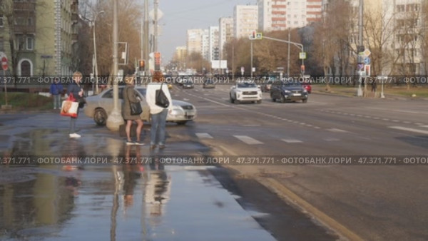Перекрёсток, машины поворачивают. Люди переходят через дорогу. Белый автомобиль нарушает правила дорожного движения. Редакционное видео, видеограф Семён Прудий / Фотобанк Лори