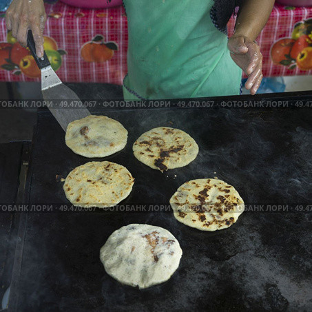 Person baking Pupusas, a traditional flatbread, San Ignacio, Belize. Стоковое фото, агентство Ingram Publishing / Фотобанк Лори