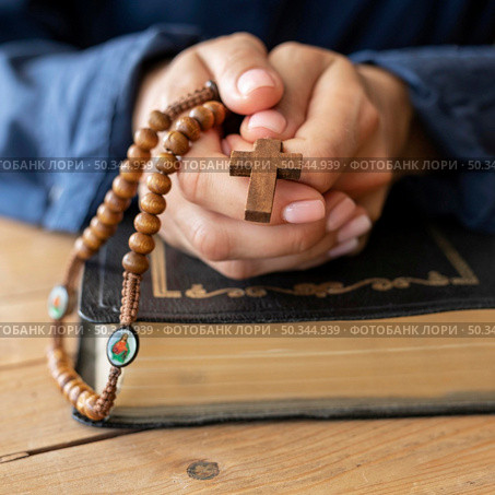 person holding rosary hands praying. Стоковое фото, агентство Ingram Publishing / Фотобанк Лори