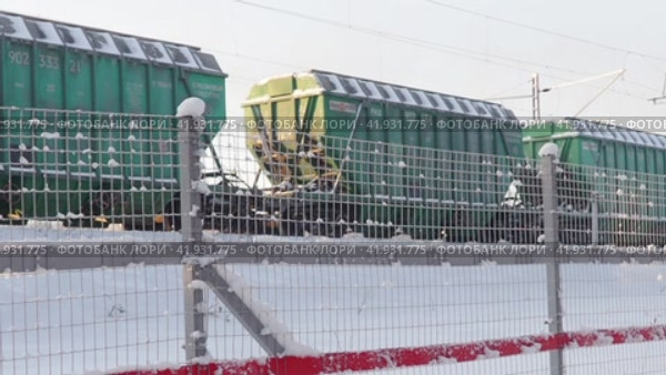 Petrozavodsk, Russia January 5, 2024. A freight train rushes along the railway tracks among snow and snowdrifts. Oktyabrskaya railway. Frosty winter day -27 degrees Celsius. Transportation of goods. Редакционное видео, видеограф Юлия Петровская / Фотобанк Лори
