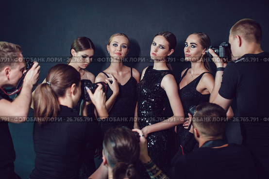 Photographers paparazzi take photos of women in cocktail dresses on dark background. Стоковое фото, фотограф Женя Канашкин / Фотобанк Лори