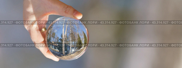Photography of the beautiful clear crystal ball. Russian tourist resort in focus. Miracle warm view. Human hand holding crystal ball. Photography is full of spring sunlight. Tourist resort. Close up. Стоковое фото, фотограф YuryKara / Фотобанк Лори