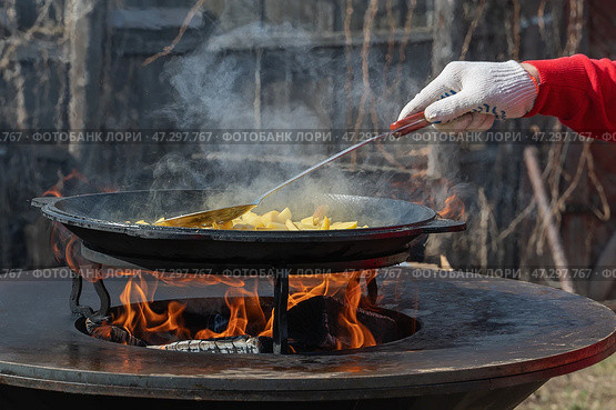 Picnic. Cook outdoors with friends using the backyard blacktop grill. The casual atmosphere showcases outdoor cooking. Стоковое фото, фотограф Оксана Медведева / Фотобанк Лори