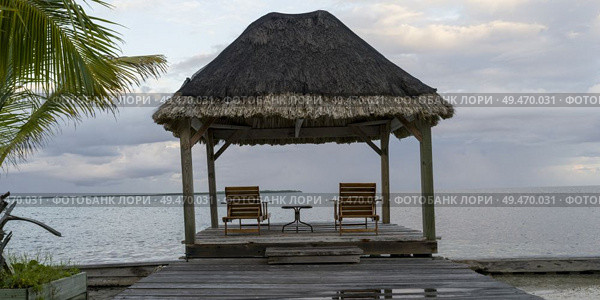 Pier with thatched roof structure, Caribbean Sea, Turneffe Island, Belize. Стоковое фото, агентство Ingram Publishing / Фотобанк Лори