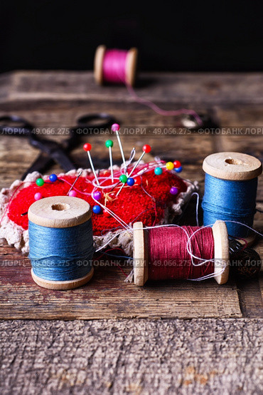 pin cushion with needles,thread and buttons for sewing on stylish wooden background. Стоковое фото, агентство Ingram Publishing / Фотобанк Лори
